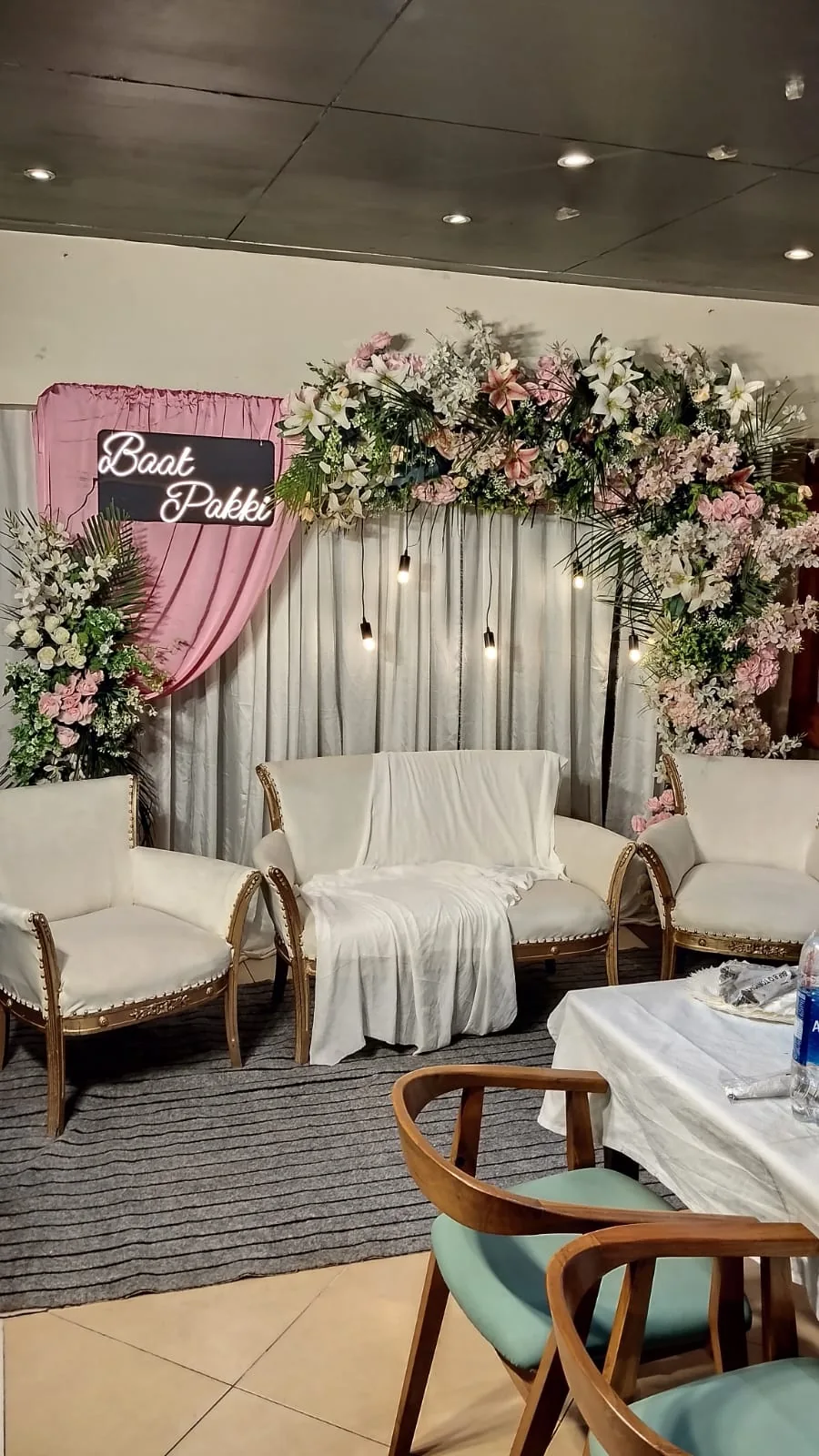 Pink draping and white floral decoration above a home seating arrangement