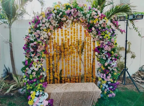 Garden backdrop combining mixed flowers, greenery and hanging yellow strands