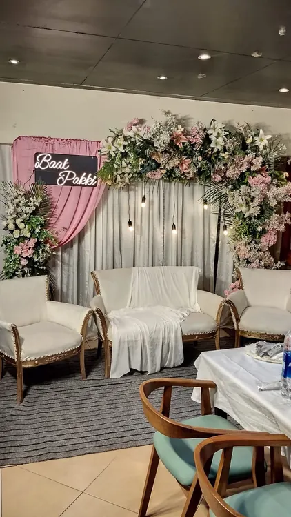 Pink draping and white floral decoration above a home seating arrangement